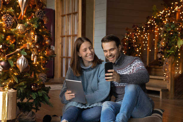 feliz pareja se divierten usando aparatos modernos en casa - couple laptop computer digital tablet fotografías e imágenes de stock