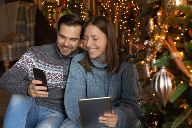 istock Happy couple relax at home using modern devices 1284784161