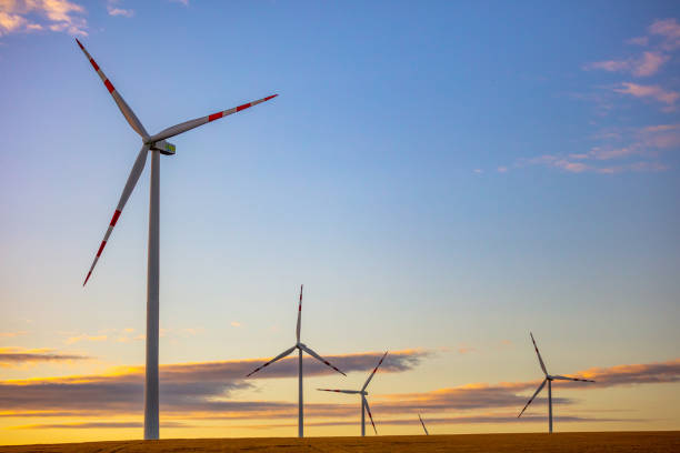 istock Wind turbines against cloudy sky at sunset 1284784480