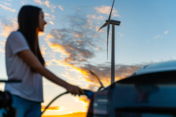 woman holding electric car charger - fuel efficiency imagens e fotografias de stock