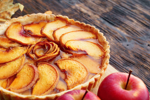istock Apple tart pie and red apples on wooden table 1284785282