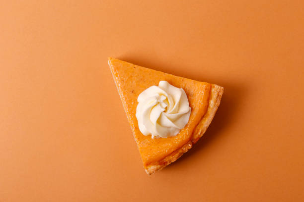 Traditional thanksgiving food on wooden table. Orange delicious homemade pumpkin pie with crust and decorative items. Thanksgiving table setting concept.Top view, close up, copy space, background.