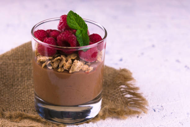 istock Chocolate pudding with raspberries in a glass on a white plate. 1284787948
