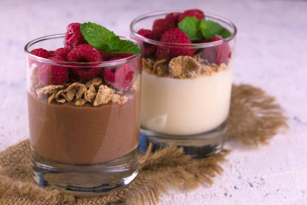 istock Vanilla and chocolate puddings in glasses on a white plate. Close-up. 1284788044