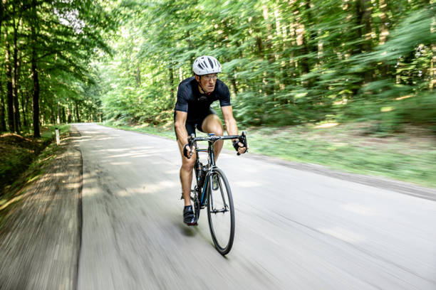 istock Cyclist driving fast through the green forest on a sunny day 1284788090