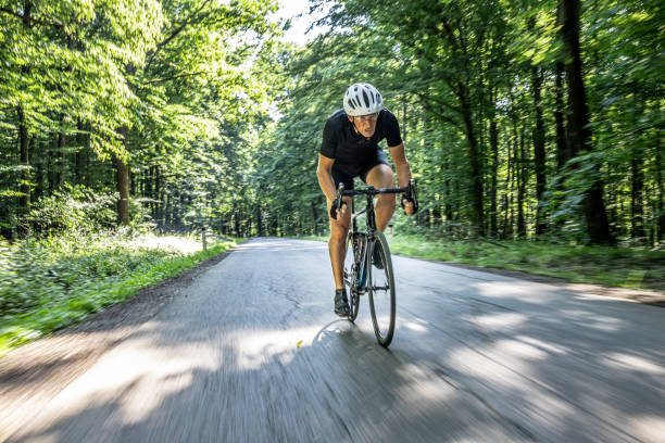 istock Cyclist driving fast through the green forest on a sunny day 1284788181