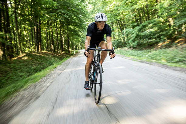 istock Man riding a professional bicycle through the forest 1284788215