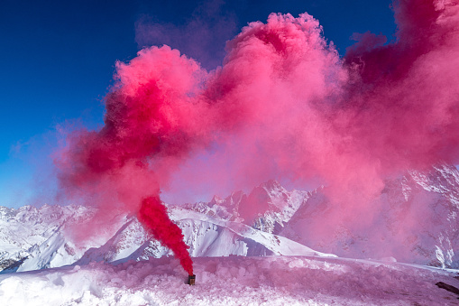 Smoke bomb with red smoke in the mountains