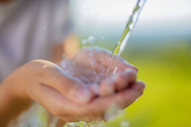 istock Woman catching pouring water in cupped hands 1284789186