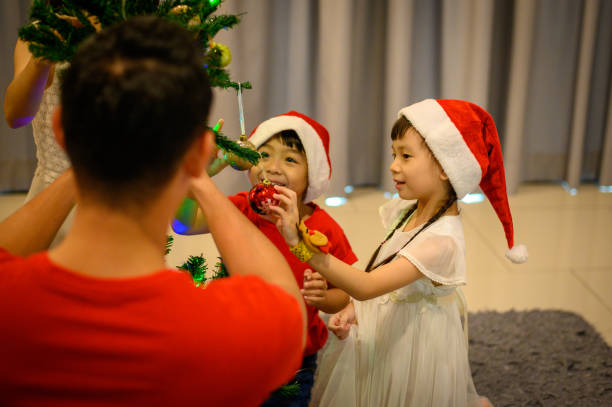 istock Kids decorating Christmas tree in beautiful living room 1284789954