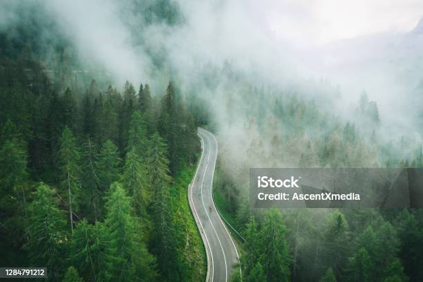 Aerial Perspective Of Road Bicyclist Riding Up A Wet Road Stock Photo - Download Image Now