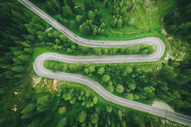 istock Aerial perspective of road curving through the forest 1284792498