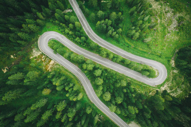 istock Aerial perspective of road curving through the forest 1284792575