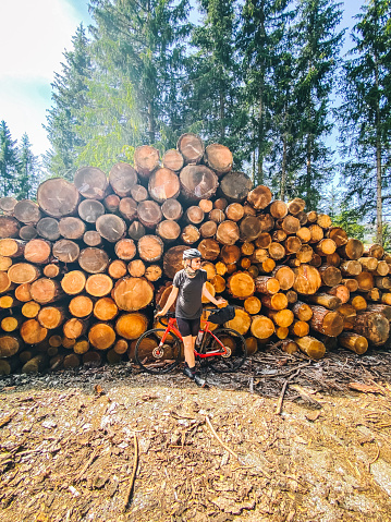 Large log pile behind him