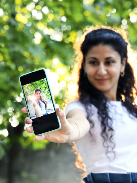 istock Young smiling armenian woman shows smartphone screen 1284795448