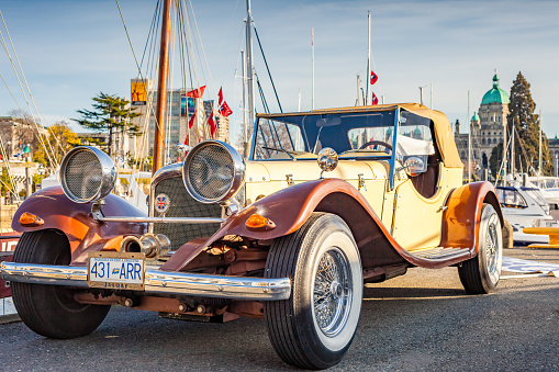 A 1930s SS Jaguar 100 convertible car is parked in downtown Victoria, BC, Canada on a sunny day.