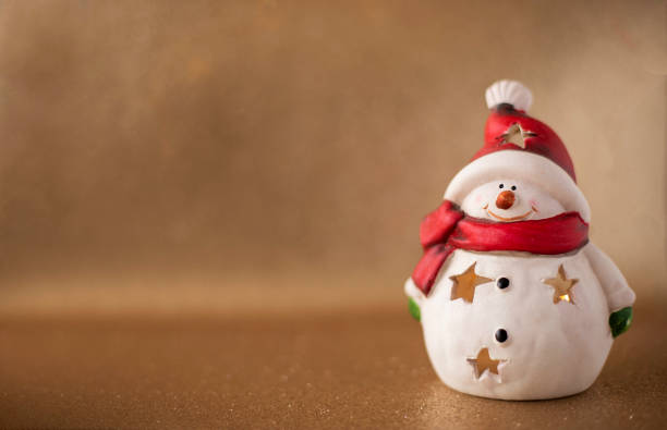 istock christmas candle lantern snowman on golden background 1284797074