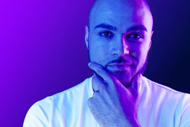 istock Serious thoughtful black guy portrait in neon light 1284797221