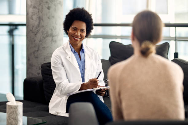 istock Happy black psychotherapist communicating with a patient during a session at the clinic. 1284801478