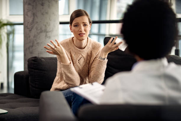 istock Uncertain woman communicating with her psychotherapist at doctor's office. 1284802039
