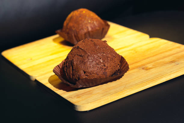 istock Two delicious handmade chocolate truffles on a wood cutting board 1284802540