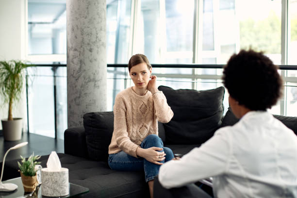 istock Young woman having appointment with a therapist at doctor's office. 1284802592