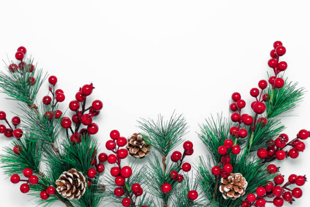 istock Christmas background with green fir tree branches, pine cones and red berries on a white backdrop. Template with copy space. Holiday concept, New Year card, ornament pattern. Mockup with decorations. 1284803791