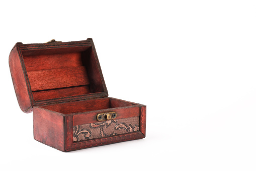 Old wooden carved closed box on white silky background close up