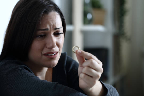 esposa triste olha para anel de casamento na noite em casa - divorce infidelity ring men - fotografias e filmes do acervo