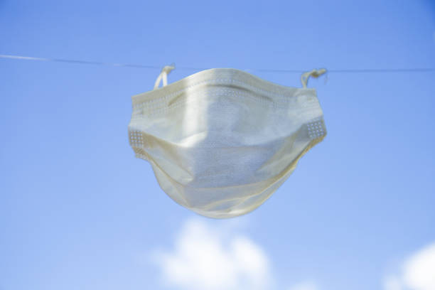 istock One protective white face mask hanging in rope 1284811326