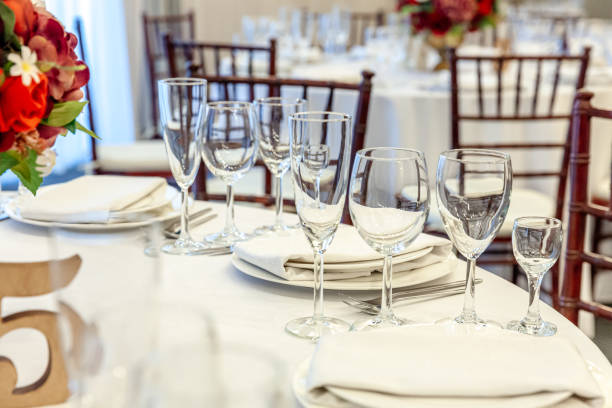 istock Fancy table set for dinner with napkin glasses in restaurant, luxury interior background. Wedding elegant banquet decoration and items for food arranged by catering service on white tablecloth table 1284811376