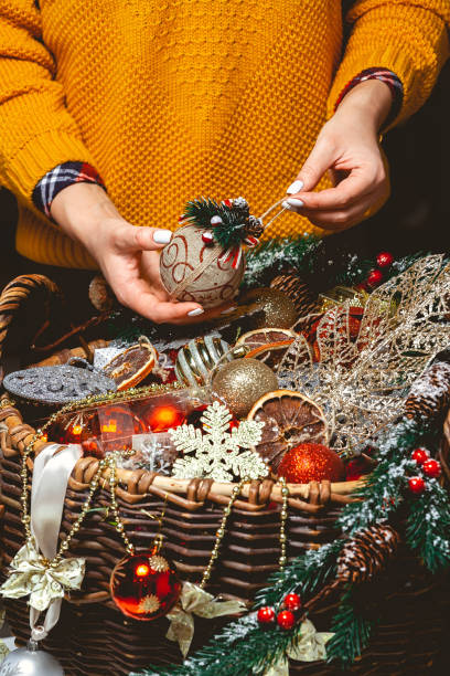 istock Young Woman with a Box Choosing Christmas Decorations in a Baske 1284811377