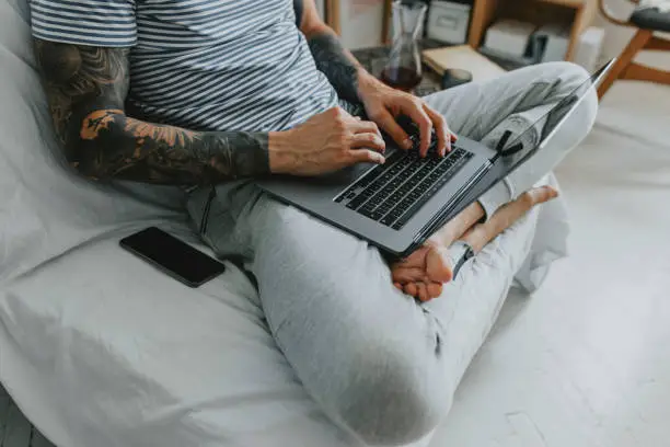 The new normal: unrecognizable young businessman working remotely from his home on a laptop PC