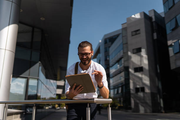 istock Young man wearing eyeglasses and using tablet at airport 1284815189