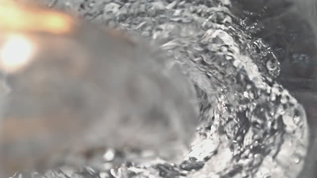 Pouring water into glass at slow motion