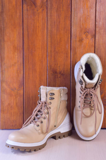 istock Two winter or autumn boots on a brown wooden background 1284817206
