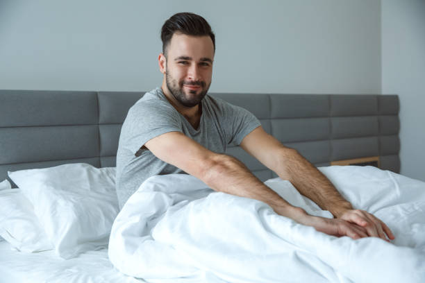 istock Bachelor man daily routine single lifestyle morning concept awakening stretching sleepy 1284822878