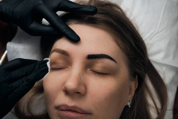 istock Permanent eyebrow makeup procedure. Eyebrow tattooing, process. The use of tools by a master for permanent eyebrow makeup. 1284823049
