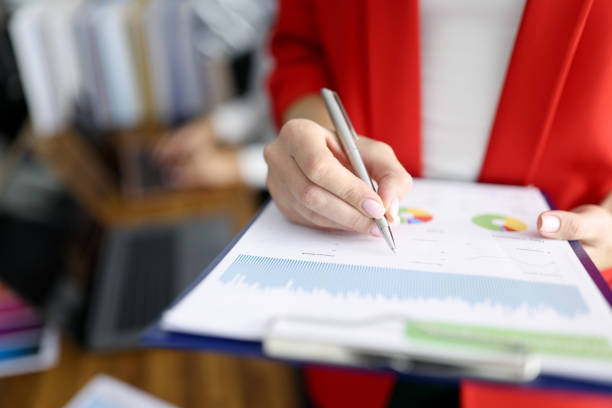 femme d’affaires dans la veste rouge retient le presse-papiers avec des documents et le plan rapproché de stylo - diagram business writing women photos et images de collection