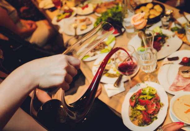 istock Sommelier pouring wine into glass from mixing bowl at luxury diner. 1284823363