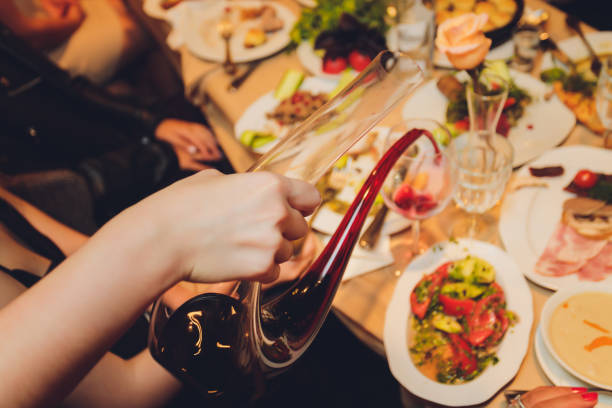 istock Sommelier pouring wine into glass from mixing bowl at luxury diner. 1284823366