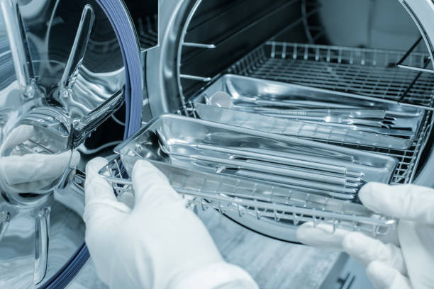 female nurse doing sterilization of dental medical instruments in autoclave. dental office - sterilizer imagens e fotografias de stock