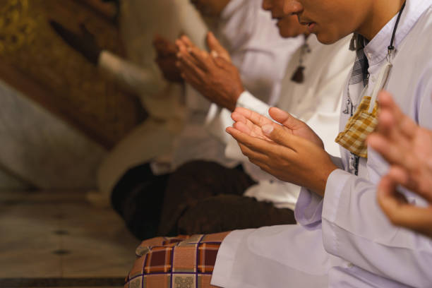 personas musulmanas que tienen la adoración y la oración por la bendición de allah en la ceremonia del islam en la mezquita durante el período de ramadán islámico enfoque selectivo a la mano - medinah temple fotografías e imágenes de stock