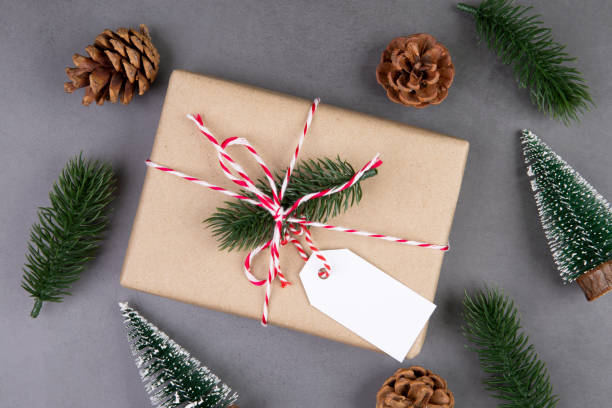 istock Christmas holiday composition with gift box having label decoration, new year and xmas or anniversary with presents having tag on cement floor background in season, top view or flat lay, copy space. 1284838332