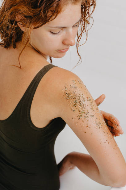istock Woman using body scrub on white background. 1284840225