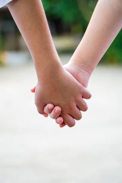 istock Brother and sister walk hand in hand 1284842462