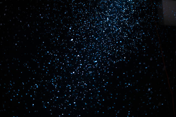 istock Wonderful winter snowfall. Snow motion filmed with studio lighting on a black background. Close up 1284848358