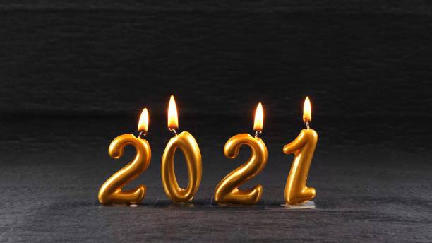 istock burning golden New Year candles 2021 on black background. modern concept 1284850168