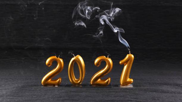istock extinguished golden New Year 2021 candles on black background. modern concept 1284850189
