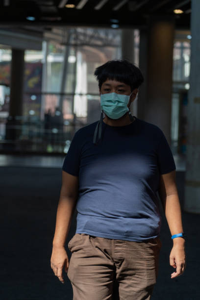 istock Man in protective face mask standing in the shadow 1284850229